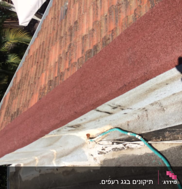 גג רעפים עם קצה אדום וצינור ירוק